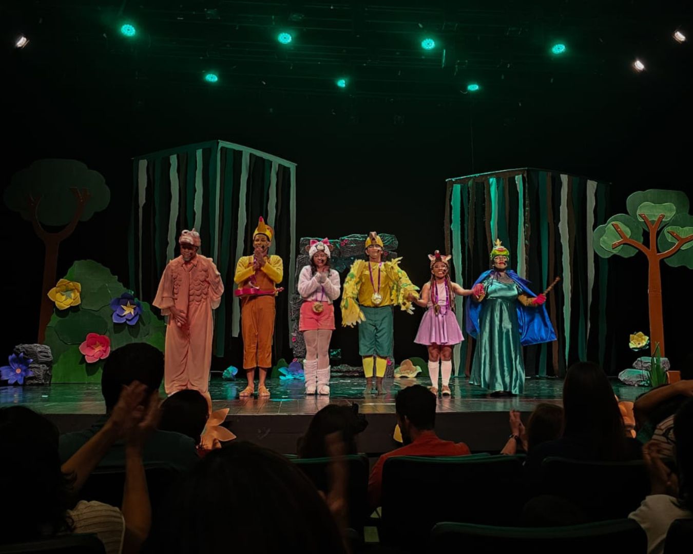 Cena do espetáculo infantil Endêmicos com atores fantasiados de animais no palco.